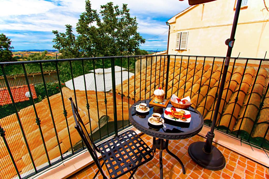 un balcone con tavolo e cibo sopra di Eden Lilli B&B a La Pieve