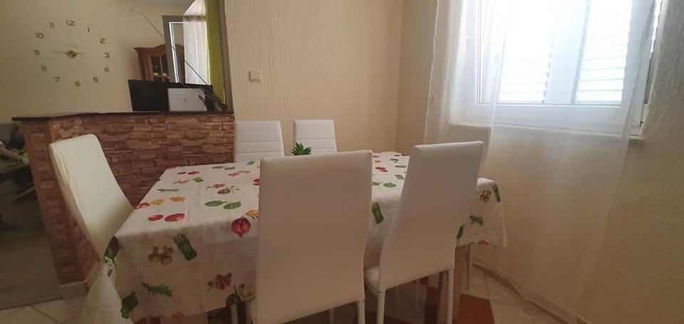 a dining room table and chairs with a floral table cloth at Apartments New Charming in Senj