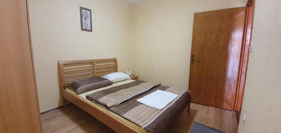 a bedroom with a bed and a wooden door at Apartments New Charming in Senj
