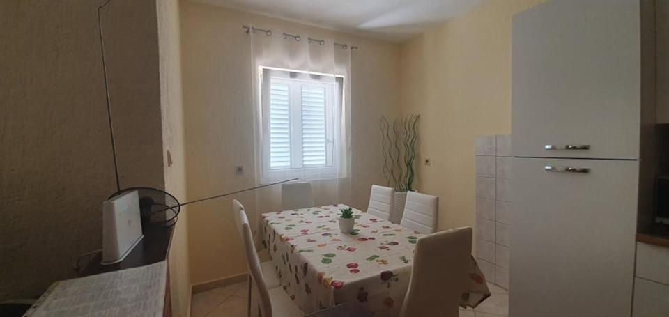 a room with a table and a kitchen with a window at Apartments New Charming in Senj