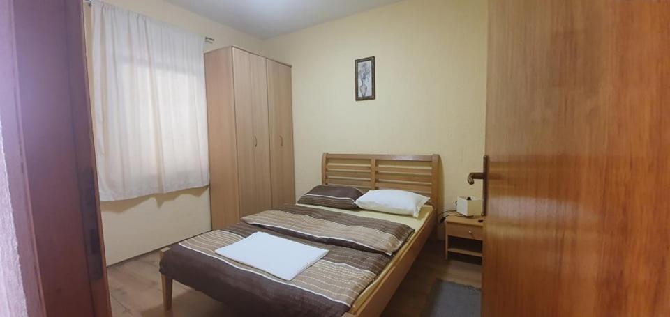 a small bedroom with a bed and a window at Apartments New Charming in Senj