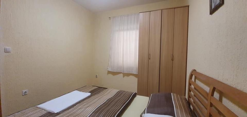 a small bedroom with a bed and a window at Apartments New Charming in Senj