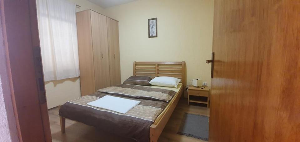a small bedroom with two beds and a wooden door at Apartments New Charming in Senj