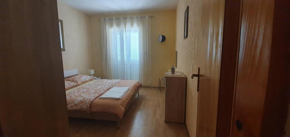 a bedroom with a bed and a large window at Apartments New Charming in Senj