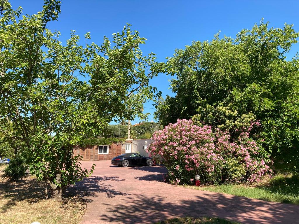 a car parked in a driveway with trees and flowers at VILLA MERCEDES 300 m de la plage in La Londe-les-Maures