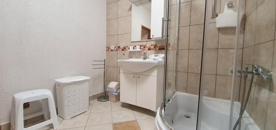 uma casa de banho com um chuveiro, um lavatório e um WC. em Apartments New Charming em Senj