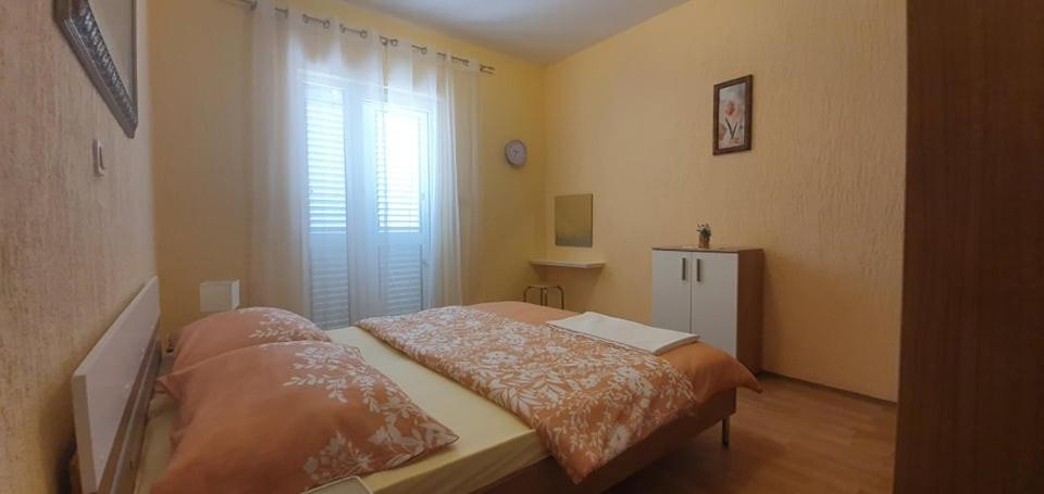 a small bedroom with a bed and a window at Apartments New Charming in Senj