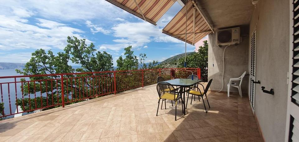 a patio with a table and chairs on a balcony at Apartments New Charming in Senj