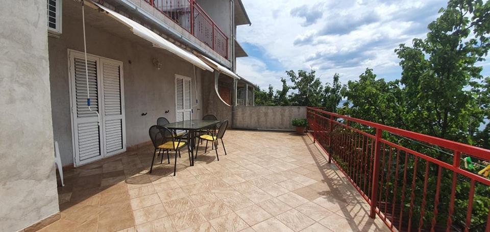 a patio with a table and chairs on a balcony at Apartments New Charming in Senj