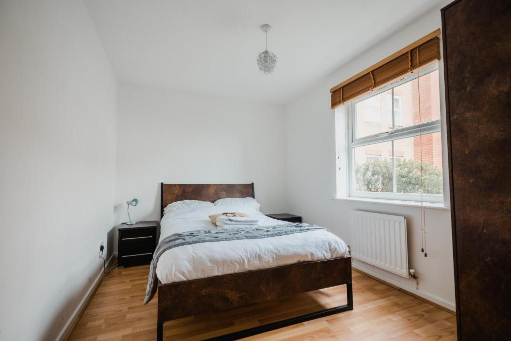 Schlafzimmer mit einem Bett und einem Fenster in der Unterkunft Hullidays - Victoria Dock Residence in Hull