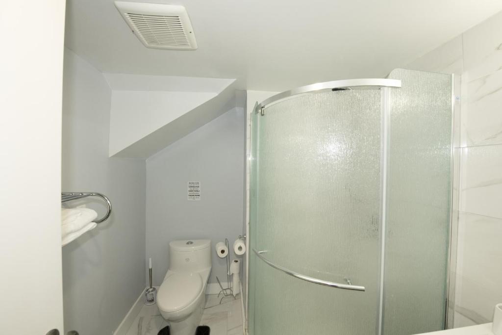 a bathroom with a toilet and a glass shower at Serene Niagara Inn in Niagara Falls