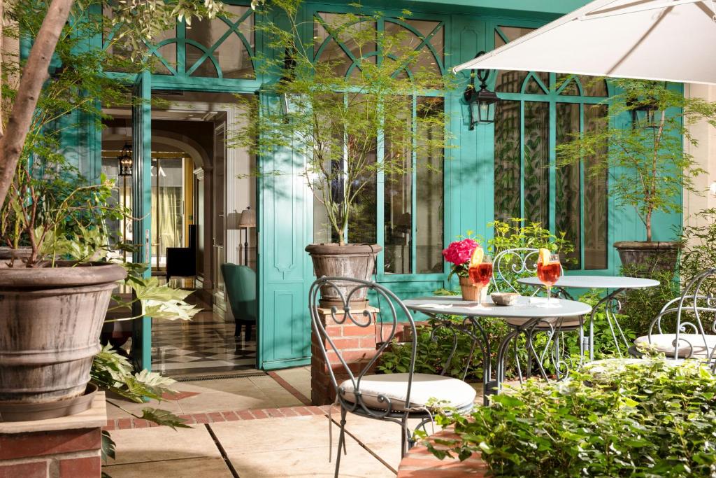 a patio with a table and chairs and plants at Serotel Lutèce in Paris