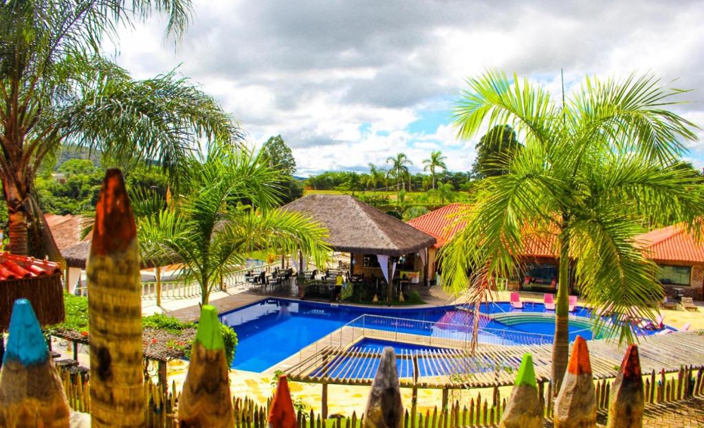 ein Resort mit einem Pool und Palmen in der Unterkunft Parque Do Avestruz Eco Resort in Esmeraldas