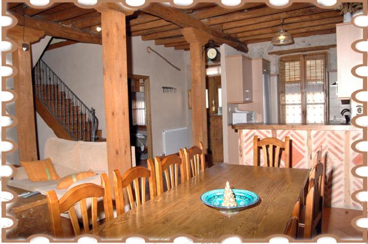 ein Esszimmer mit einem Holztisch und Stühlen in der Unterkunft Casa Rural la Ribera in Cabezuela