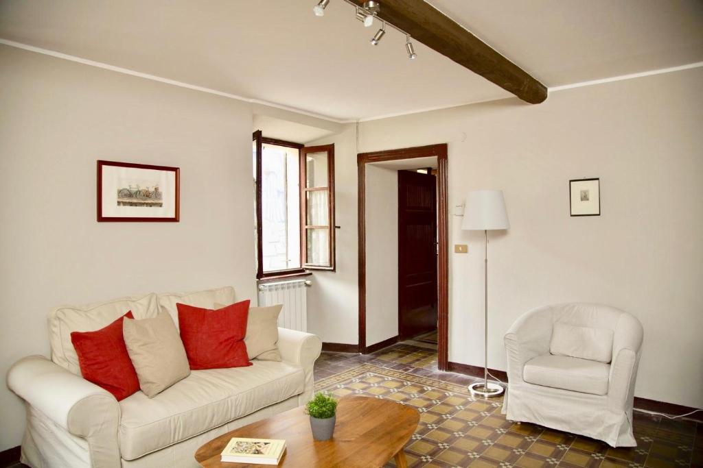 sala de estar con sofá blanco y silla en Contempora Apartments - Ca' Brenta Dudù, en San Fedele Intelvi