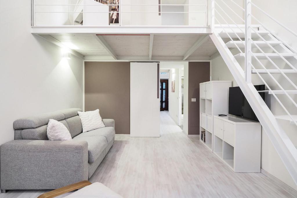 ein Wohnzimmer mit einem Sofa und einer Treppe in der Unterkunft Contempora Apartments - Breno 2 in Mailand