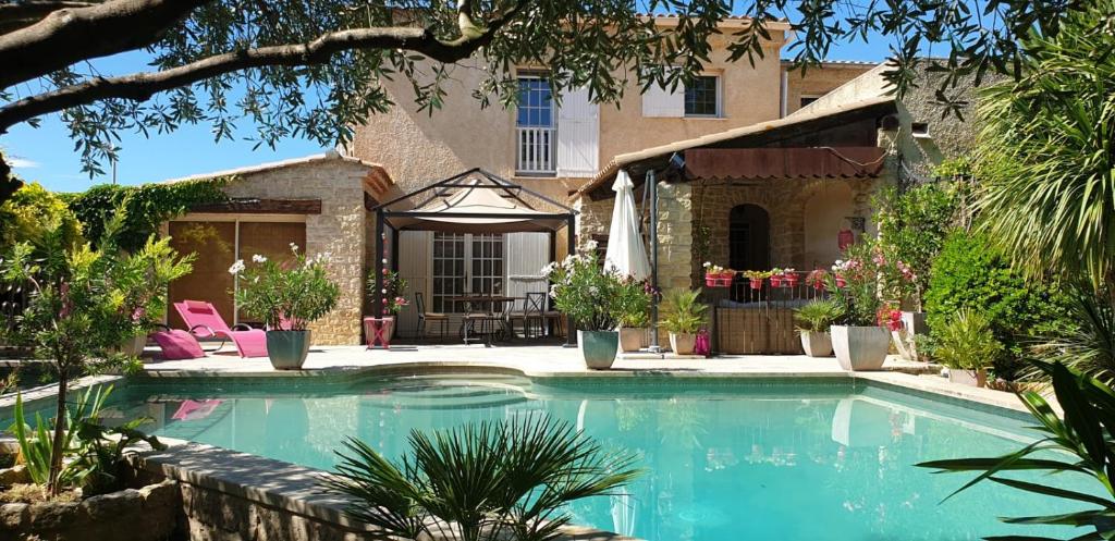 a swimming pool in front of a house at Villa Solary in Le Pontet