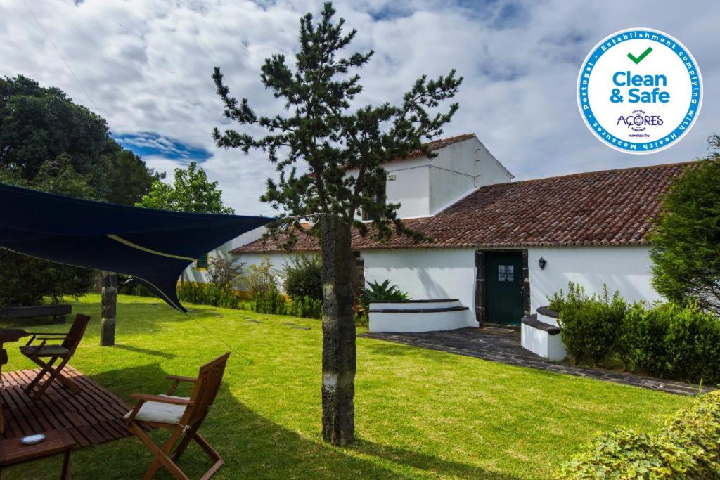 a garden with a tree and a house at Casa Villa Garden in Ponta Delgada