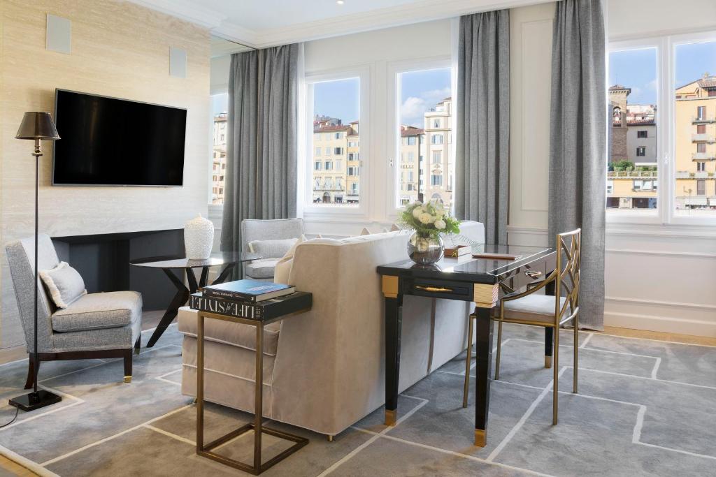 a living room with a couch and a table and a television at Lungarno Luxury Apartments - by Lungarno Collection in Florence