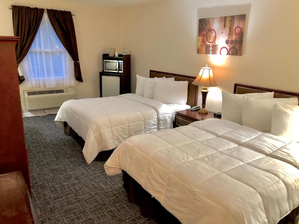 um quarto de hotel com duas camas e uma janela em Bicentennial Inn em Buckhannon