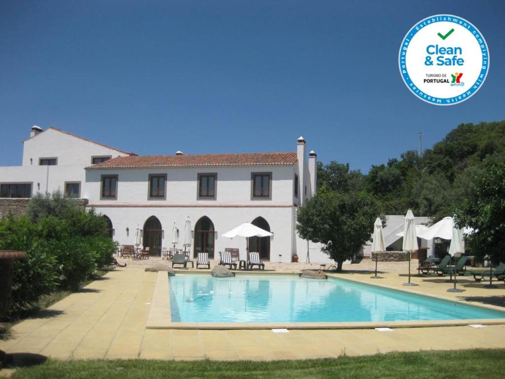 un bâtiment avec une piscine en face d'un bâtiment dans l'établissement Convento da Provença, à Portalegre