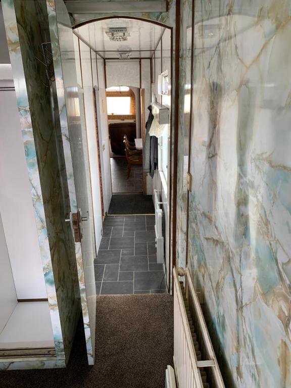 a hallway in a train car with a tile floor at Vintage, Circus Holiday Home in Mablethorpe