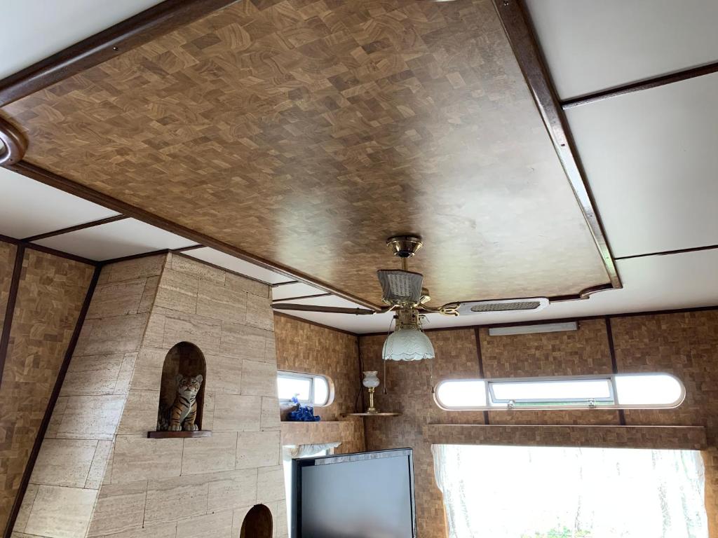 a room with a ceiling with a fan and a tv at Vintage, Circus Holiday Home in Mablethorpe