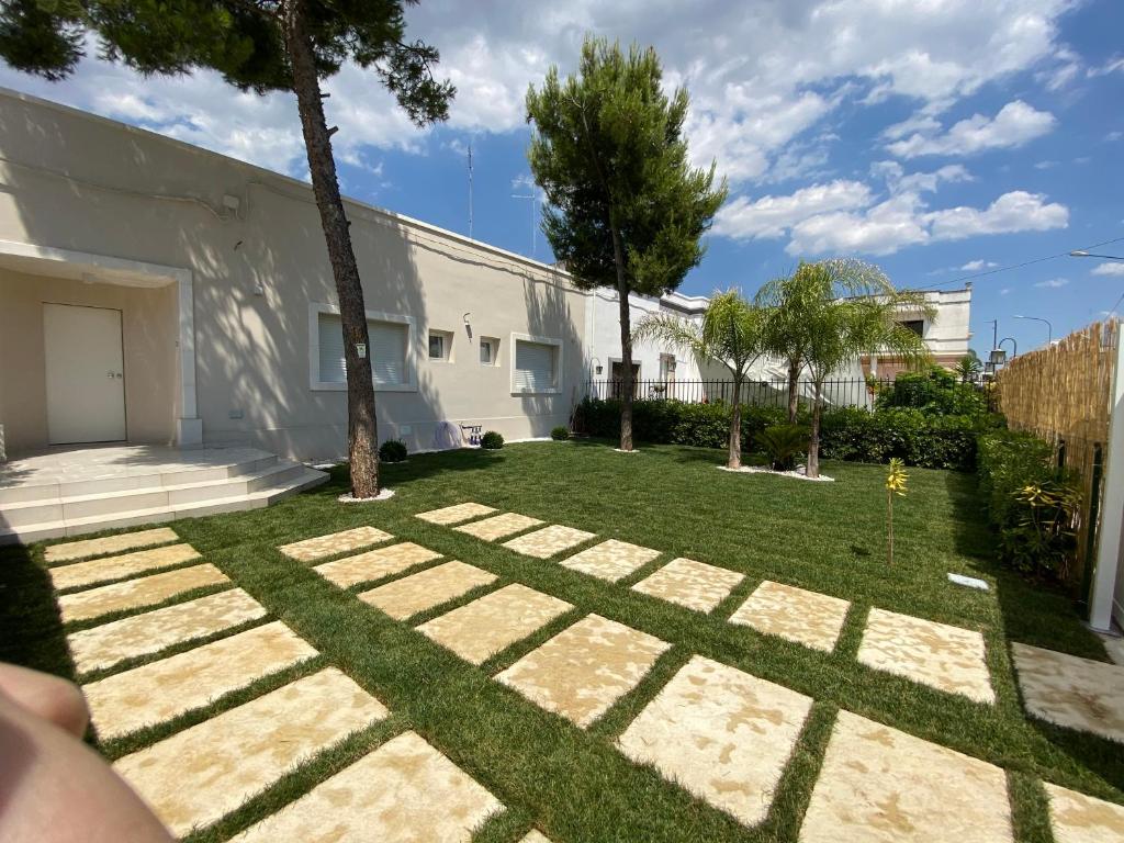 a yard with grass and trees and a building at PalÈat B&B in Manduria
