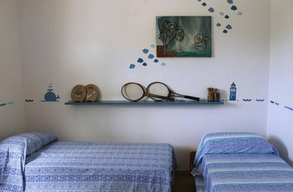 a bedroom with two beds and a shelf with shoes at Casa Azzurra in Conca Specchiulla
