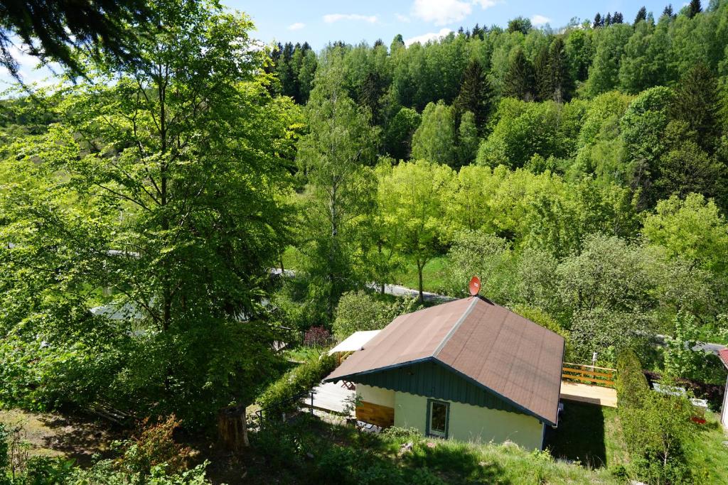 ein Haus mit einem braunen Dach in einem Wald in der Unterkunft Ferienhaus Hellaberg in Langenbach