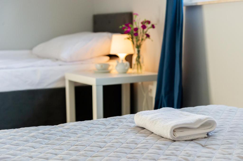 1 cama con manta blanca y mesa con lámpara en Veroma en Ostrowo
