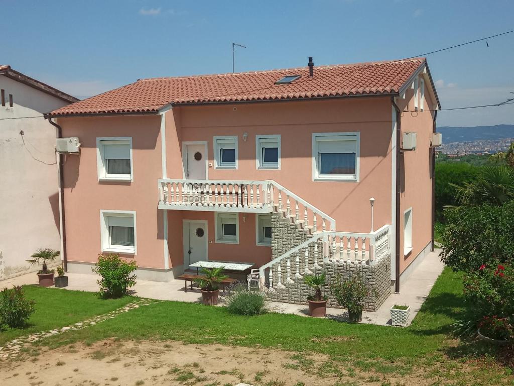 una casa con balcone e scale in un cortile di ANKARAN SOBE MARA ad Ancarano