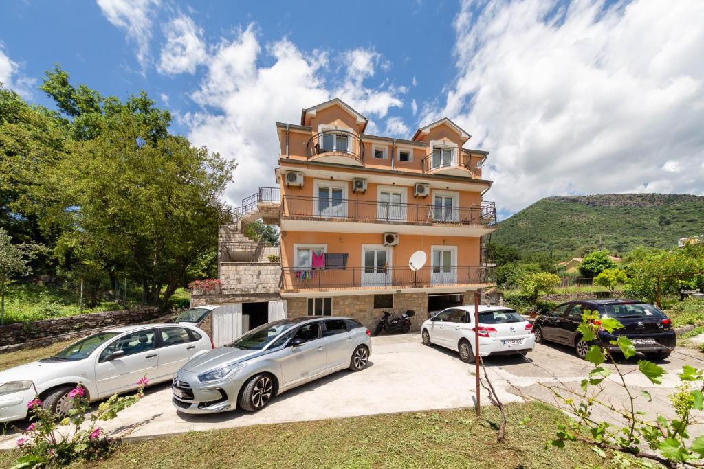 una casa con tres coches aparcados delante de ella en Apartments Pelle en Tivat