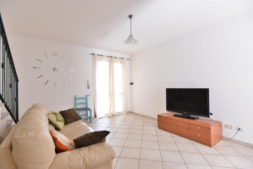 IzzHome Comfort في بولا: غرفة معيشة مع أريكة وتلفزيون بشاشة مسطحة