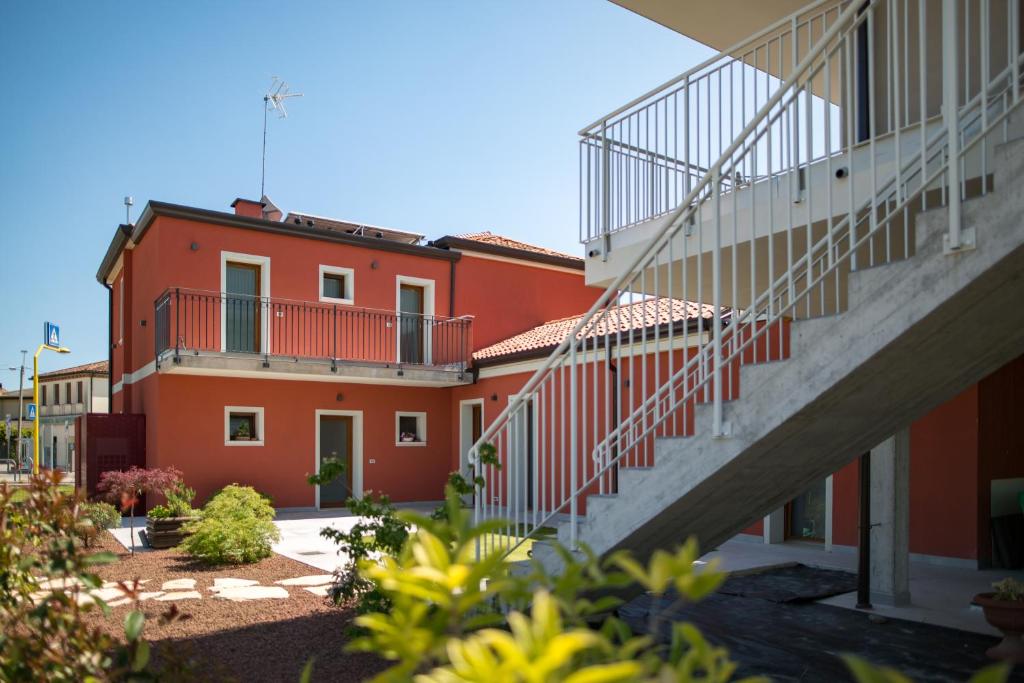 een rood gebouw met een trap ervoor bij Guest House Bella Onda in Tessera