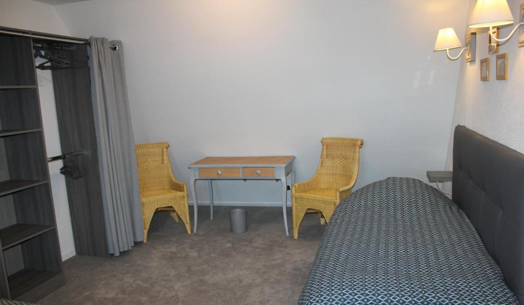 a bedroom with a bed and a table and two chairs at Gîte Le Cep d&#39;Or Alsace in Saint-Hippolyte