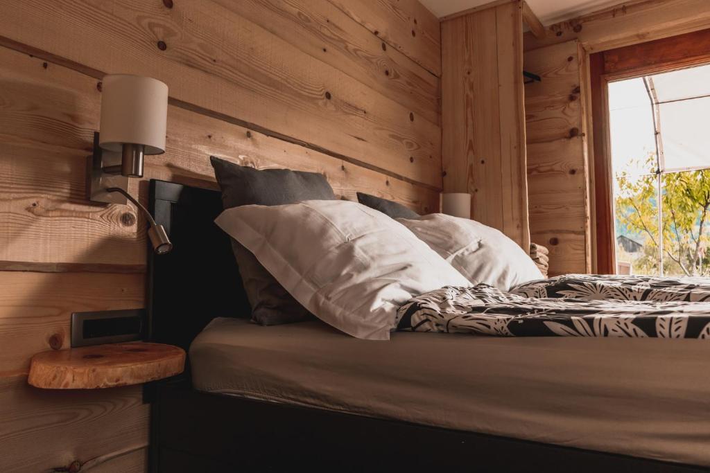 a bedroom with wooden walls and a bed with a window at Vintgar studio in Zgornje Gorje