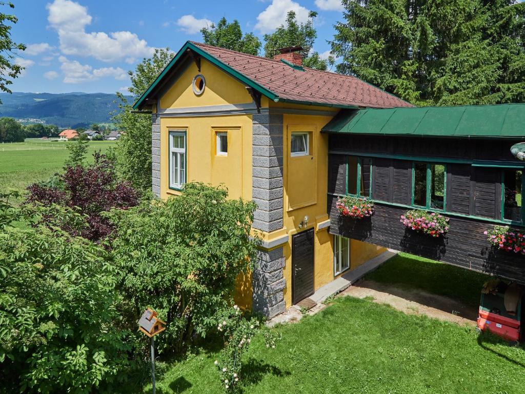 a yellow house with flowers in a yard at Ferienhaus Krieglach in Krieglach