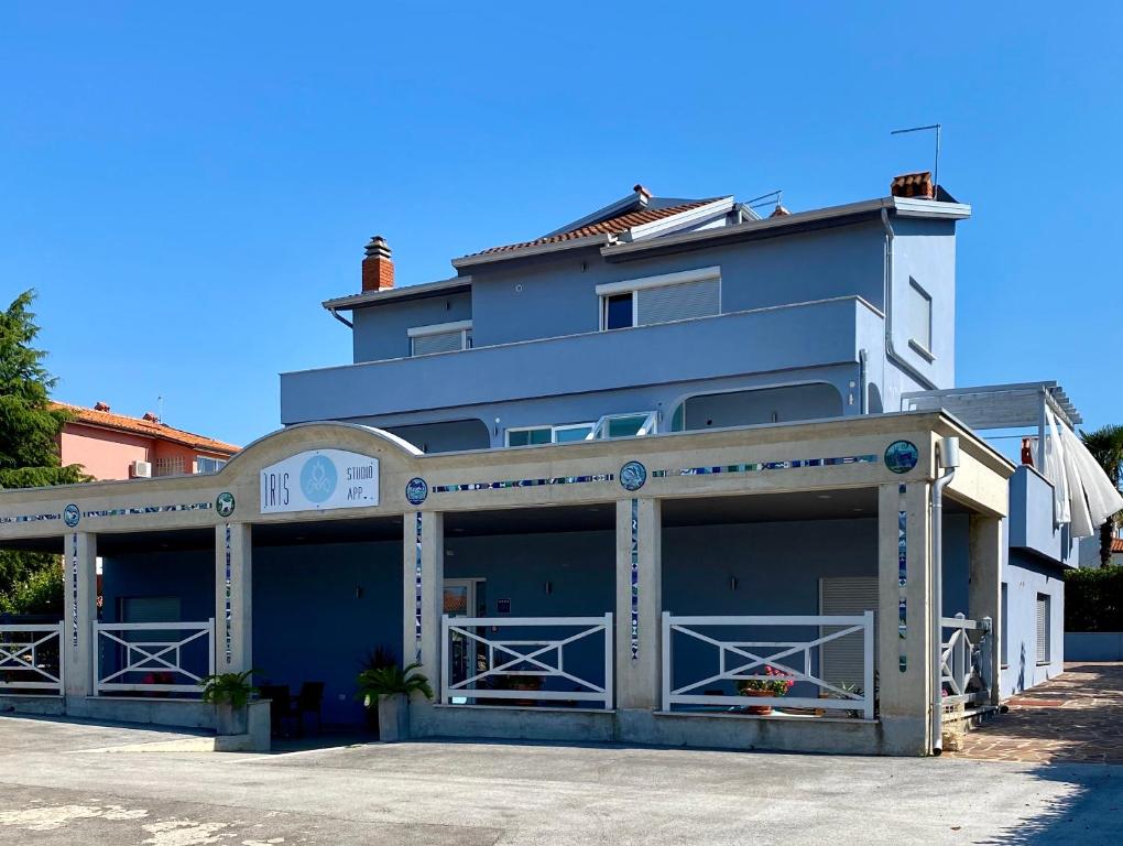 un gran edificio azul con un gran garaje en Iris Studios, en Umag