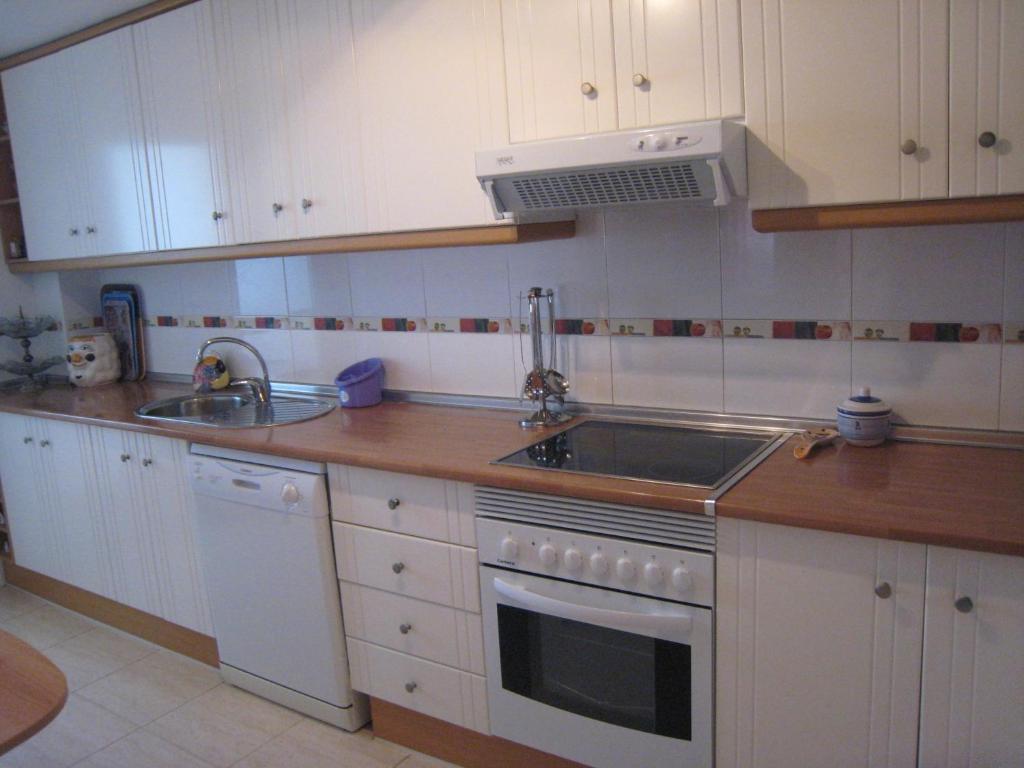uma cozinha com um lavatório e um fogão forno superior em Apartamentos Turísticos Puerto Tomás Maestre em La Manga del Mar Menor