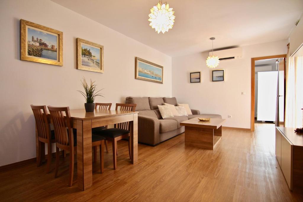salon ze stołem i kanapą w obiekcie Apartamento CONFORTABLE junto al Mercado w Kadyksie
