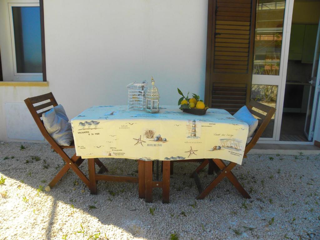 una mesa con 2 sillas y una mesa con fruta. en Stagnone Kitesurf Paradise en Birgi Vecchi