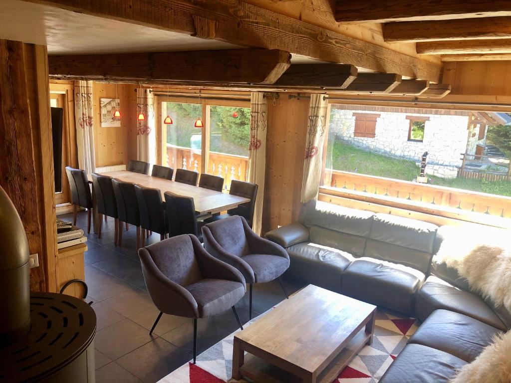 uma sala de estar com um sofá, uma mesa e cadeiras em Chalet l'écureuil em Méribel