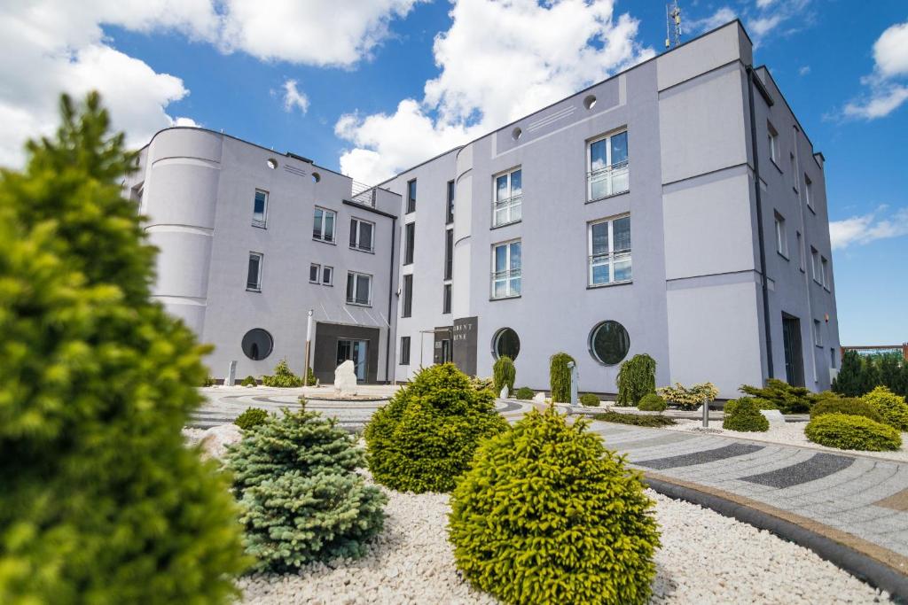 a large white building with bushes in front of it at Resident Rene USTKA in Ustka