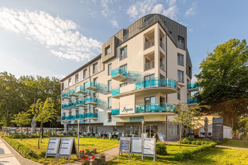 un edificio de apartamentos con balcones y letreros frente a él en Laguna, en Świnoujście
