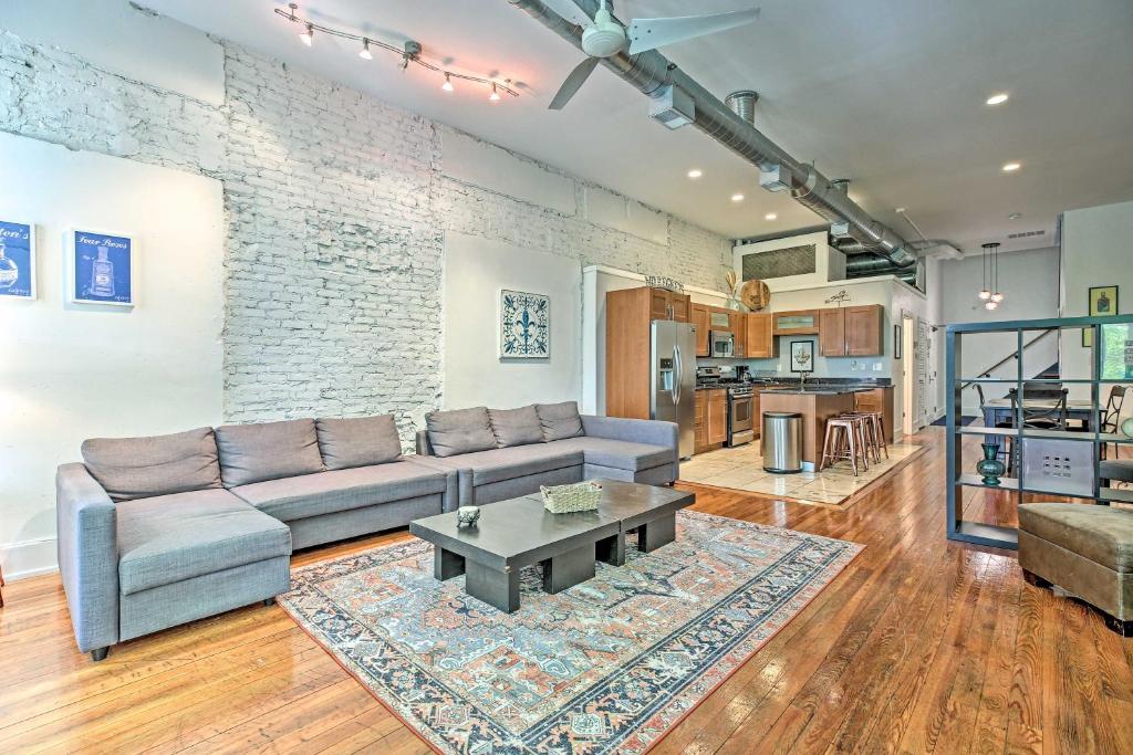 a living room with a couch and a table at Nulu Art District Loft Walk to Dtwn Distilleries! in Louisville