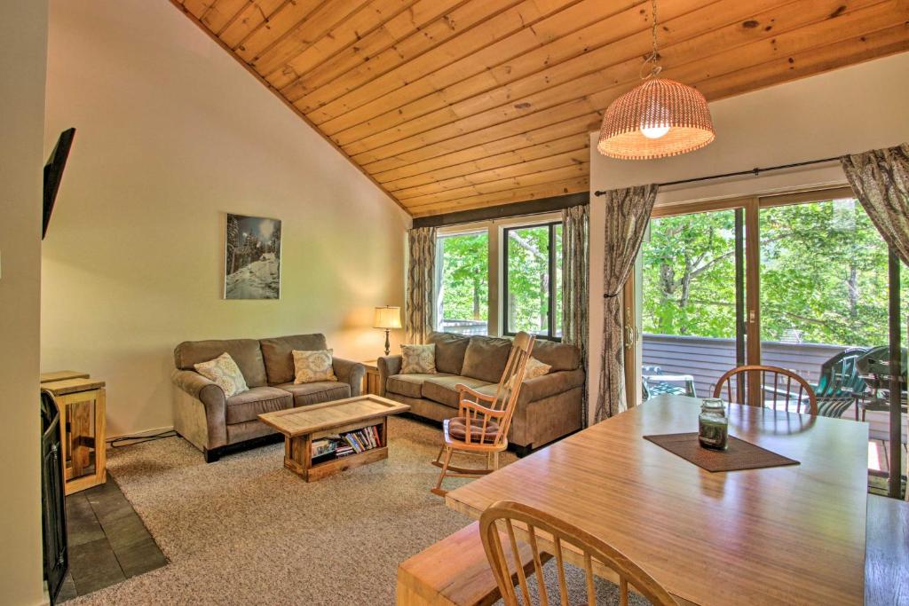 a living room with a couch and a table at Village of Loon Mtn Condo with Fireplace and Balcony! in Lincoln