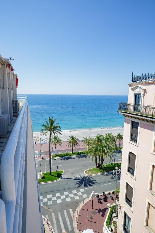 une vue sur la plage depuis le balcon d'un immeuble dans l'établissement Lovely apartment near the sea 25 bis Promenade des Anglais, à Nice
