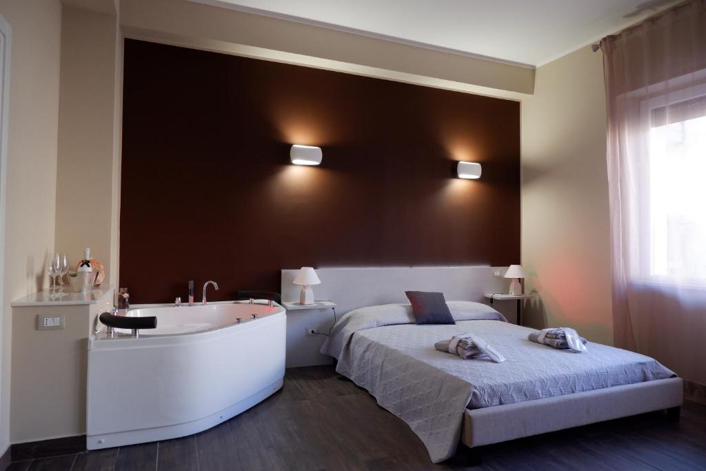um quarto com uma banheira, uma cama e um lavatório em Leus Appartment em Reggio di Calabria
