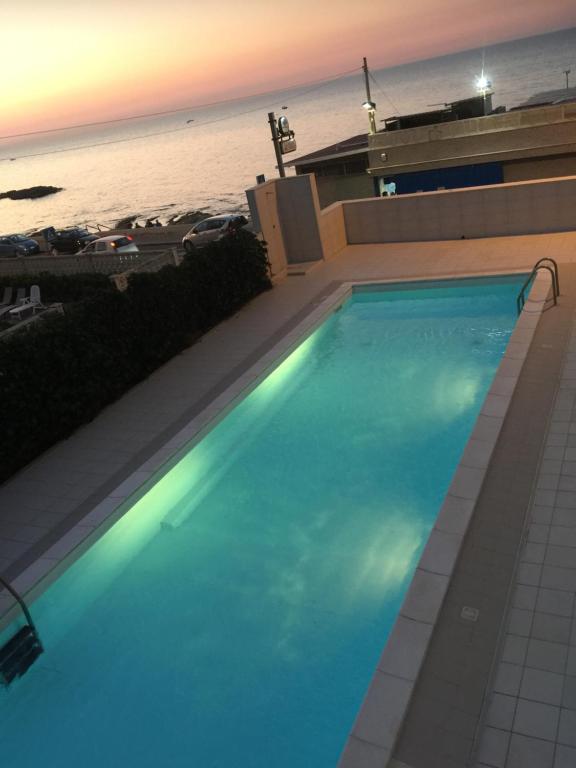 a large swimming pool with the ocean in the background at Palese Profumo di Mare in Santo Spirito